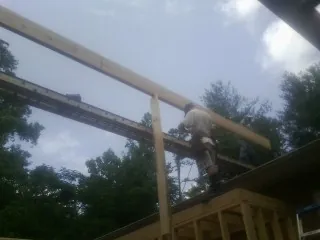 Carpenter setting a ridge beam over a new addition frame — Ice Dam Removal by Roofing Brothers in Gainesville